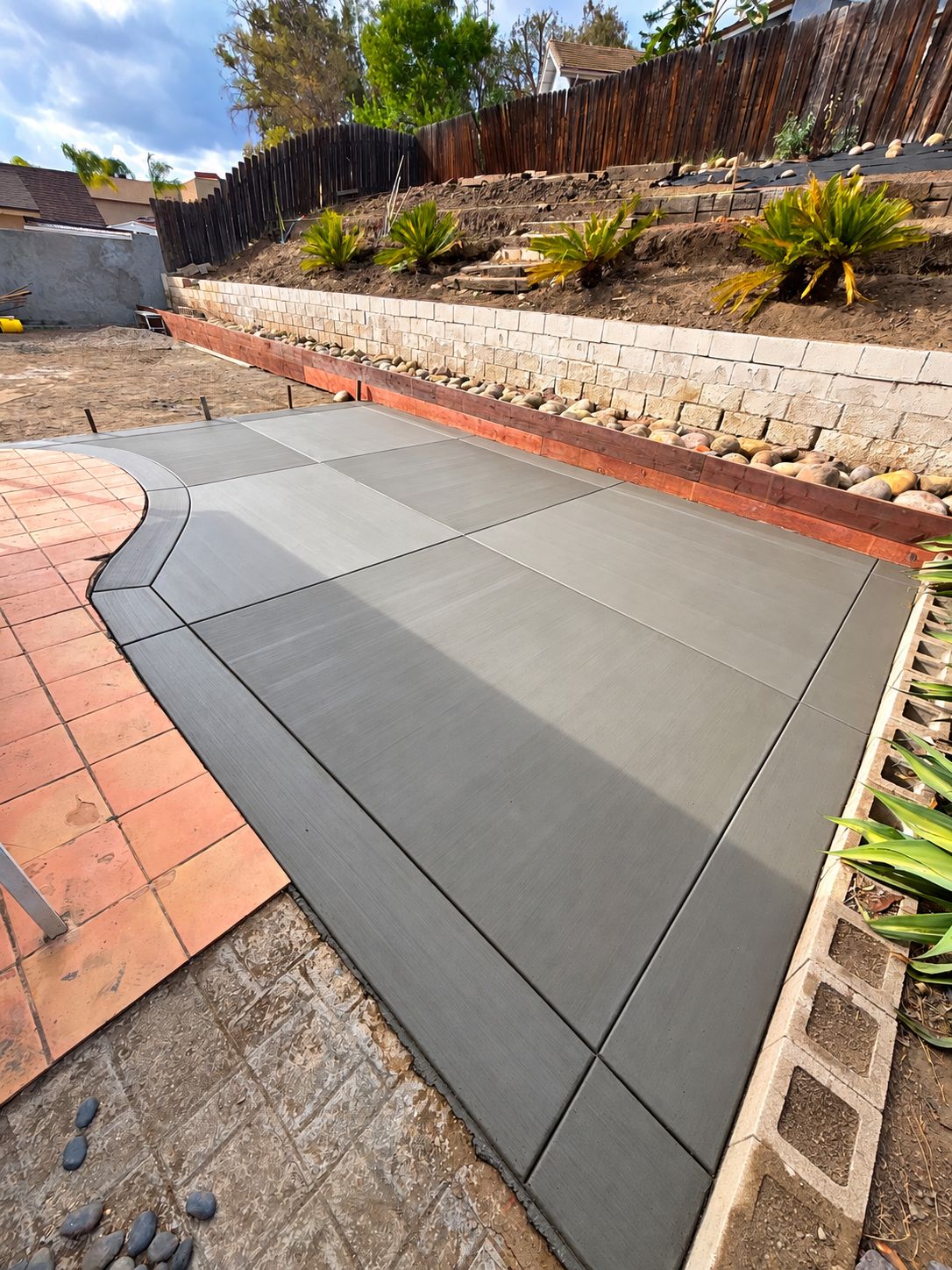 Finished concrete slab with crisp edges beside a stamped patio