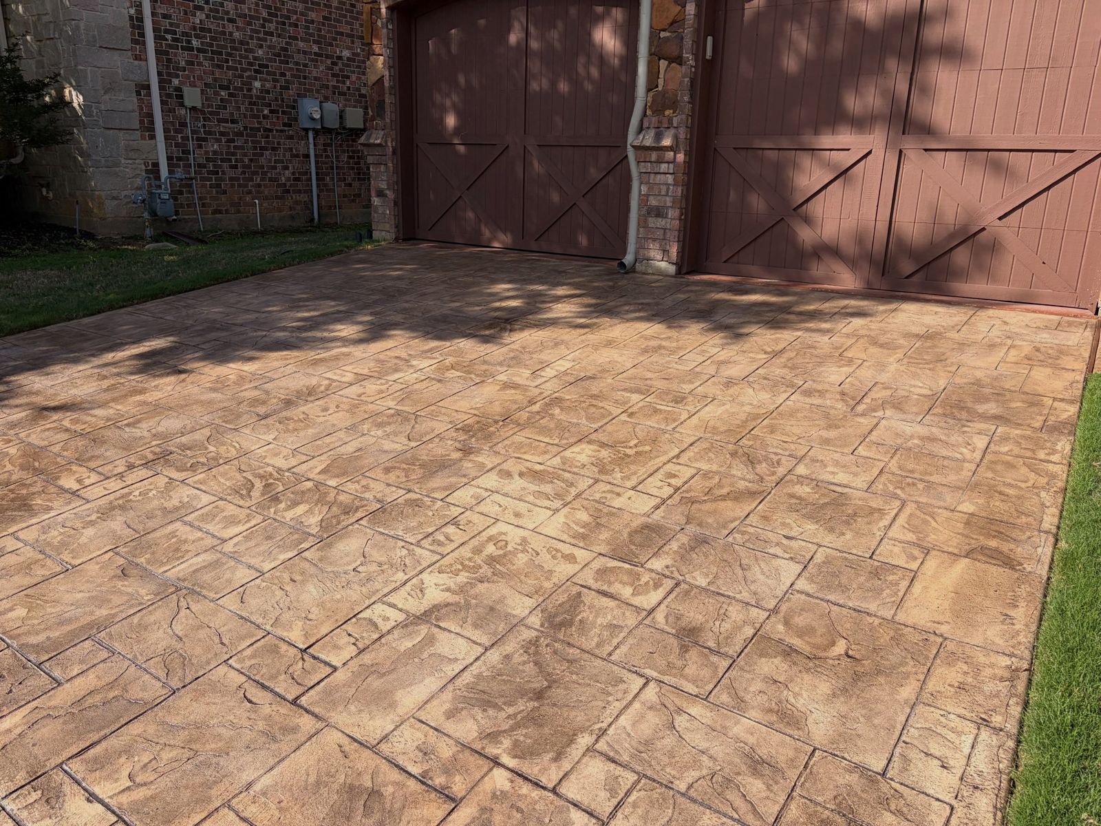Stamped and stained ashlar-pattern concrete in front of a garage