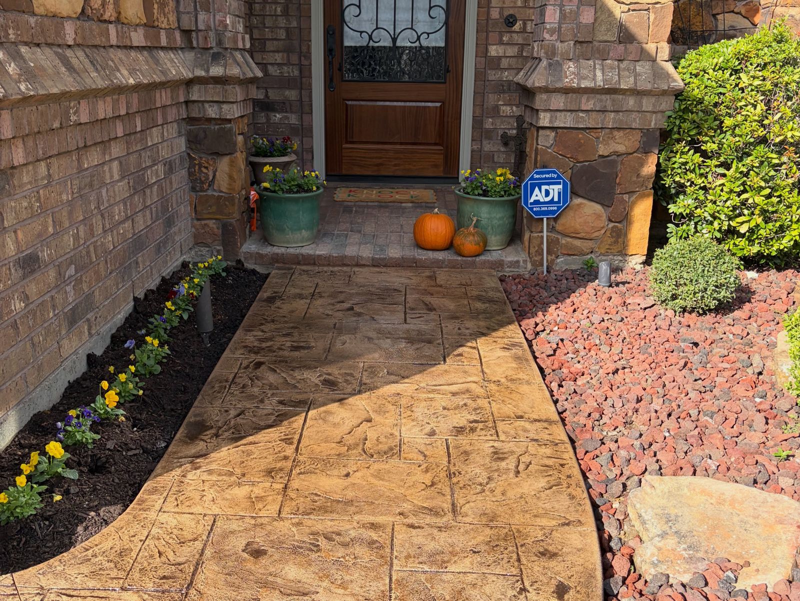 Stamped concrete front walkway to a brick home